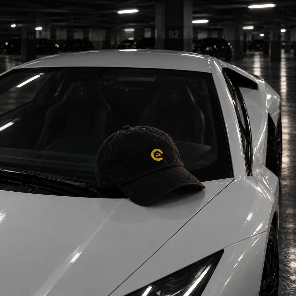 Casquette Carspot noire brodée posée sur le capot d'une supercar blanche