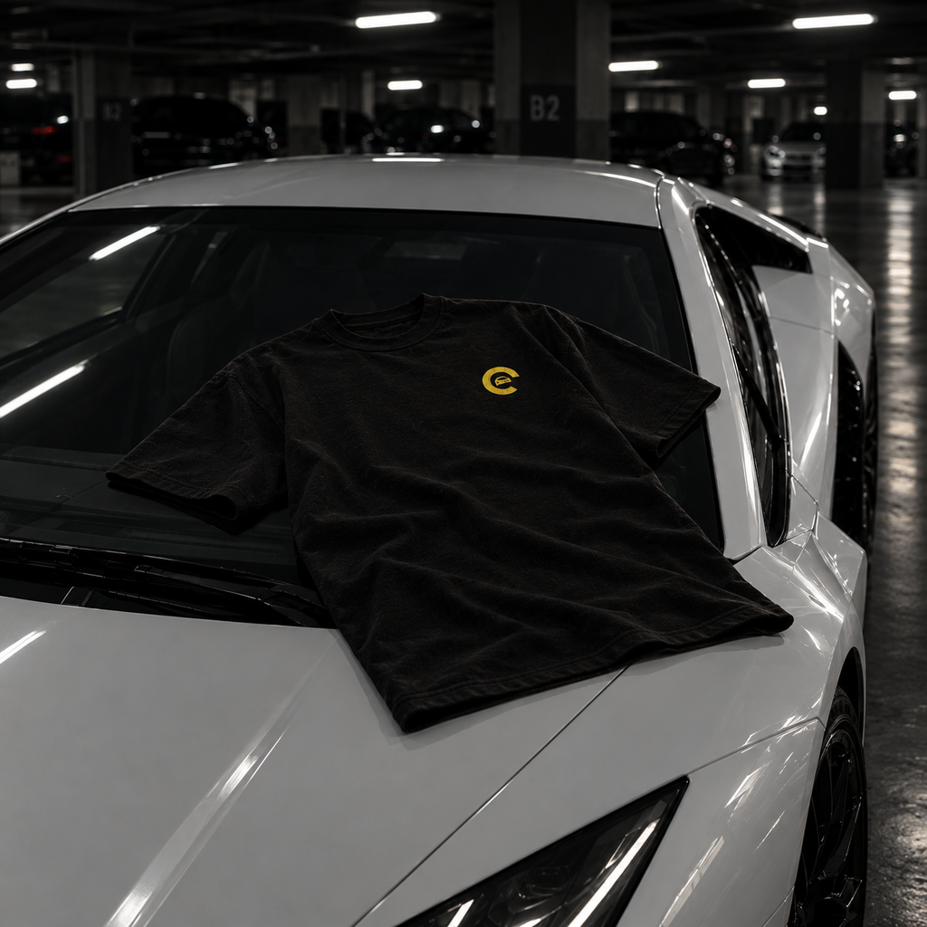 T-shirt Carspot noir brodé posé sur le capot d'une supercar blanche